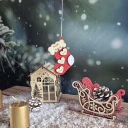 Décoration de Noël en bois en forme de chaussette rouge, personnalisée avec un nom de famille et des prénoms sur des cœurs.