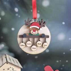 Détail de la boule de Noël en bois avec un renne coloré et cinq petites boules gravées de prénoms.