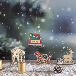 Décoration de Noël en bois en forme de voiture rouge transportant un sapin, personnalisée avec des prénoms et un nom de famille.